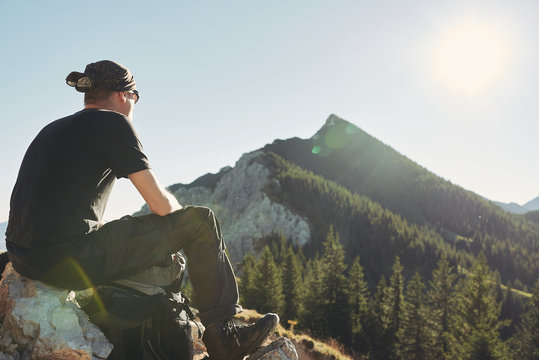 Mann sitzt auf einem Berg Gipfel und schaut auf die Berge, Himmel, Sonne, blau, Freiheit