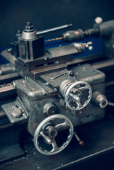 Fototapeta premium Beautiful matte silver metal industrial machinery steel cog handles in a rustic industrial factory setting. Well used processing machinery parts.