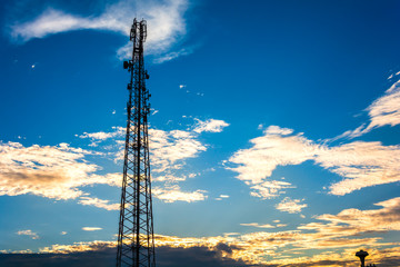 Telecommunication cellular tower in sunset sky.