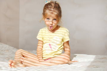 Fototapeta premium Portrait of a cute girl showing tongue in the morning. Joke