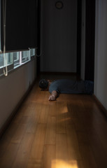 An old man lying down unconscious from a sudden heart attack in front of his bed room in a modern...
