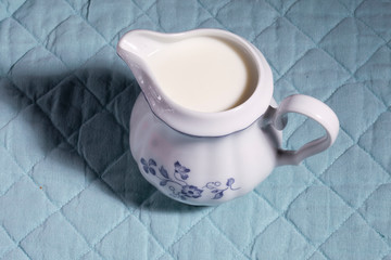 Retro milkman with milk on a blue tablecloth background