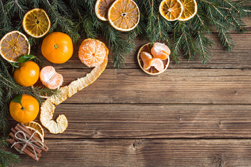 Christmas composition. cinnamon sticks and homemade orange slices on wooden background free space for inscription