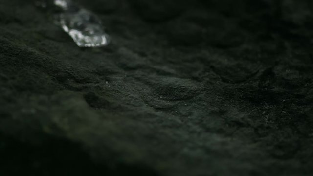 Rivulet of water running down a stone in slowmotion HD