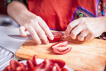preparing sun dried tomatoes, woman slicing tomato