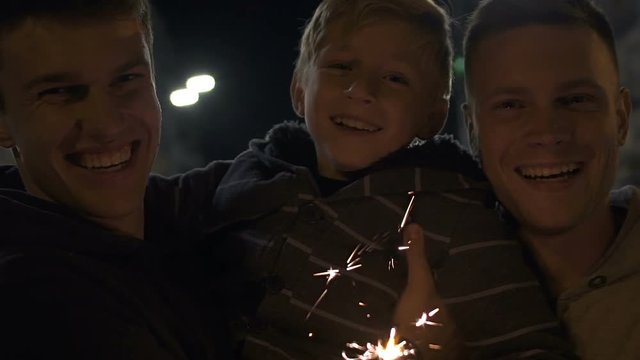 Cheerful gay family with adopted son celebrate guy Fawkes night, happy together