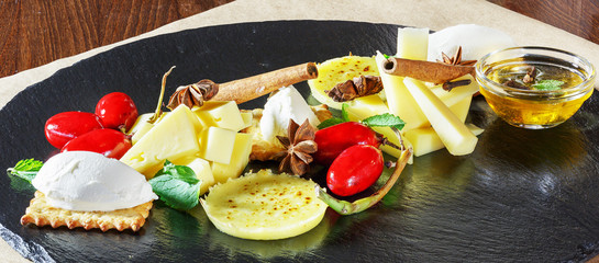 Cheese slices, cheese appetizer on a plate on the table