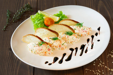 Salad on a white plate on a wooden table