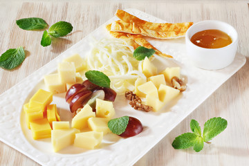 Cheese slices, cheese appetizer on a plate on the table