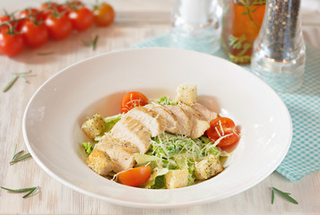 Dish of meat and vegetables on a white plate on a wooden table