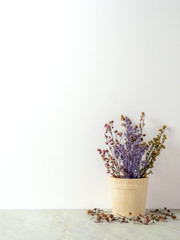 Group of bouquet dried and wilted multiple color Gypsophila flowers in wood bucket on matt marble floor and white background