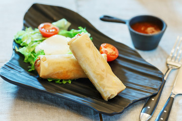 Spring rolls in a plate on the table