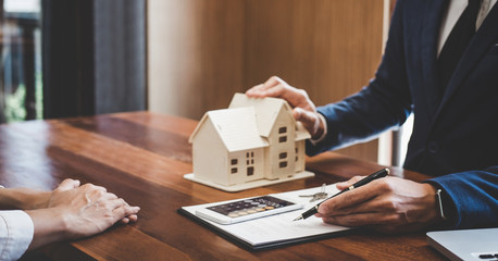 Real estate broker agent presenting and consult to customer to decision making sign insurance form...