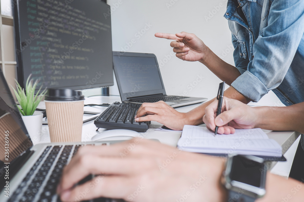 Fototapete programmers cooperating at developing programming and website working in a software develop company 
