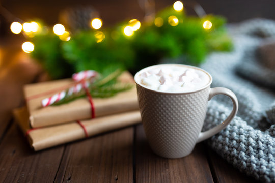 Christmas or New Year or winter concept. Mug cup of coffee cacao hot chocolate with marshmallow, gifts on dark background. Winter holidays concept. Selective focus. Cozy Christmas decor.