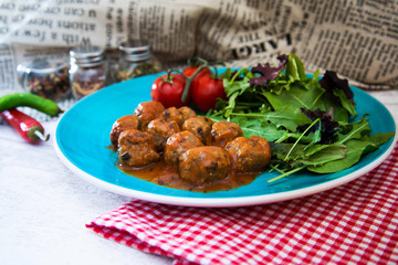 Meatball, bacon and potatoes with lettuce on white plat