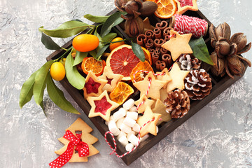 Christmas cookies, nuts and spices in wooden box on  background