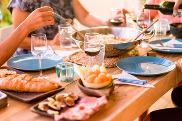 close up of group of people together celebrating and enjoying lunch in friendship with a lot of nice food tasty on the table - eating with friends concept for leisure activity - drink and eat