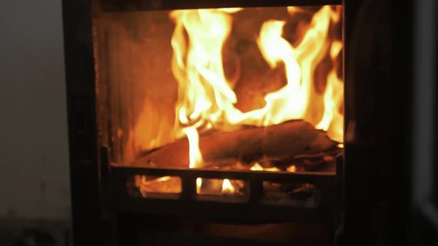 Opening stove and putting sticks on fire