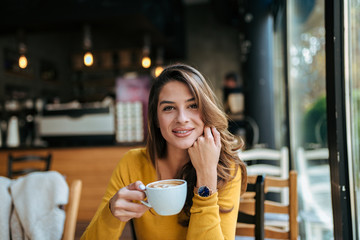 Portrait of a young lady drinking coffee.