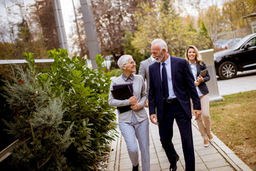 Senior and young businesspeople walking outdoor