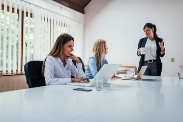 Three young business women at the meeting in a conference room.