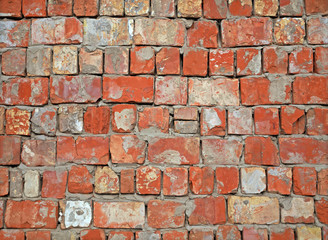 Old red brick brick wall with messy masonry. Unfavorable district