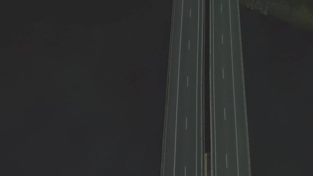 drone flying above bridge on road