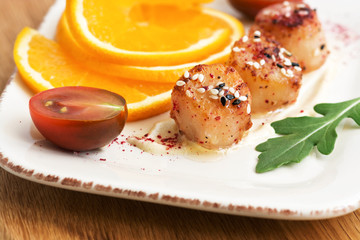 Closeup of fried scallops with orange, selective focus.