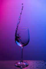 Water splashing out of a wine glass.