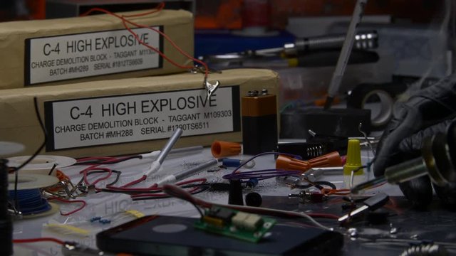 SLOW PUSH IN ON THE HANDS OF A TERRORIST MAKING A HIGH EXPLOSIVE BOMB.  4K, 10 BIT, 4:2:2 ECU SLIDER SHOT.