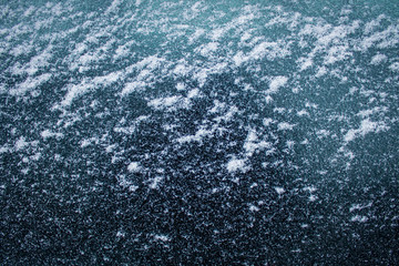 the texture of white fine snow on the glass. Background for cold winter
