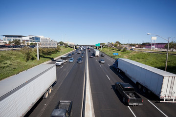 Highway traffic with semi and pickup trucks in the foreground.