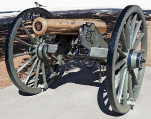 Cannon with bird resting on carriage wheel.