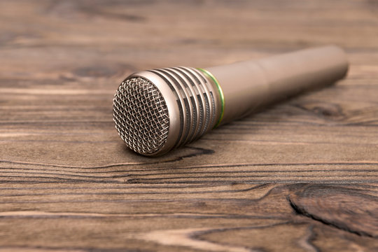 microphone for singing on wooden background. music.