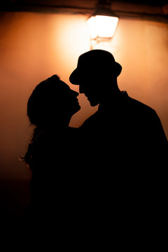 Silhouette of two lovers about to kiss.