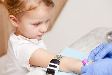 Nurse takes a blood sample from little girls arm - pediatric venipuncture  procedure