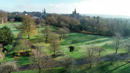 Fototapeta na wymiar Low level aerial image of Pittencrieff Park in Dunfermline on an early winter’s day with hazy sunlight.