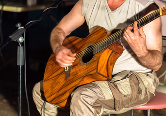 Man playing yellowe an acoustic guitar closeup