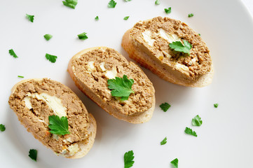open sandwiches with turkey liver spread made with butter decorated with parsley