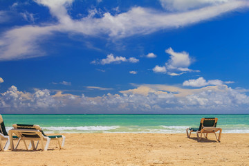 Beach chairs by the turquoise water on a tropical beach in the Caribbean sea, Freeport, Bahamas