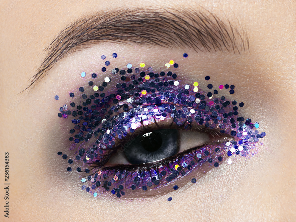 Poster beautiful macro shot of female eye with ceremonial makeup. perfect shape of eyebrows, eyeliner and p