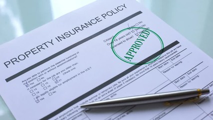 Approved property insurance policy, hand stamping seal on official paper closeup