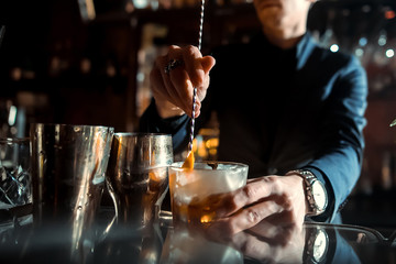 Expert Bartender is making cocktail at bar. - obrazy, fototapety, plakaty