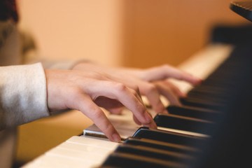 Fototapeta na wymiar children's hands on the piano keys, rehearsal music, learning to play the piano