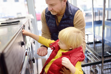 Little boy puts token in the washing machine in the public Laundry