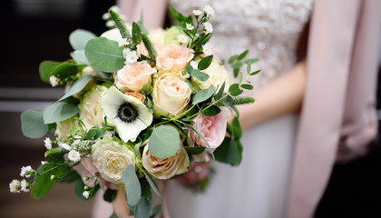 Bride holding stylish wedding flowers bouquet