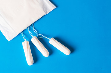 Menstruation tampons for women hygiene on the blue background.