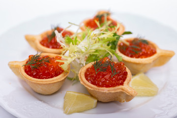 Tartlets with red caviar on a plate. Selective focus. Serve red caviar

