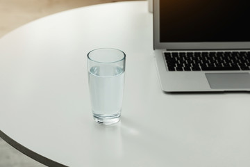 Glass of fresh water on table indoors. Space for text